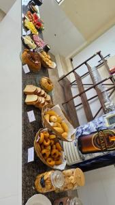 a table with various types of bread and snacks at Pousada Serra do Sol in Mariana
