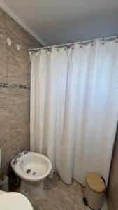 a bathroom with a white shower curtain and a toilet at casa mar in Playa Unión
