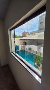 a view of a swimming pool through a window at Pousada Serra do Sol in Mariana