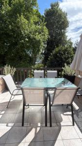 a glass table and two chairs on a patio at The Big apartment Papa Nero Pelion in Agios Ioannis Pelio