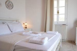 a white bed with two towels on top of it at Rocky Beach House in Kythira
