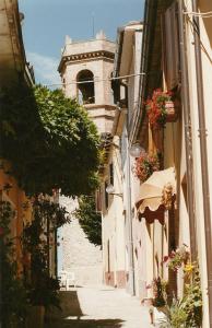 a narrow street with a clock tower in the distance at Albergo Ristorante Il Torrione in Auditore