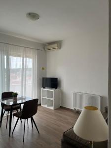 a living room with a table and chairs and a television at Apartments & Rooms Alagić in Makarska