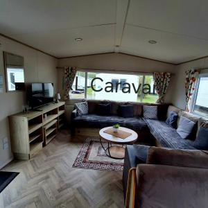 a living room with a couch and a table at KL Caravan in Prestatyn