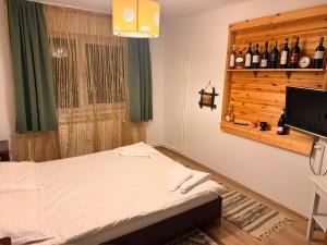 a bedroom with a bed and a window with wine bottles at Casa Cosmin in Dobra