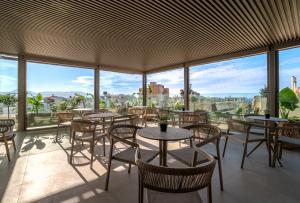 a restaurant with tables and chairs and large windows at Minotaur's Rest - Luxury Residences with Free Private Parking, near Port & Airport in Heraklio