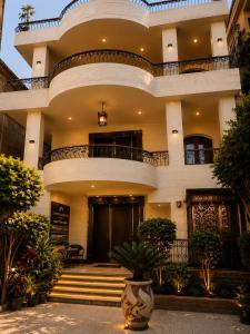 a large white building with stairs and a balcony at Sol Pyramids Rooftop View Giza in Cairo