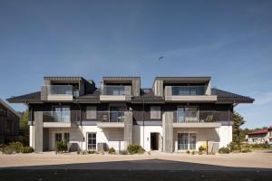 an apartment building with a black roof at Nida Breeze Apartments in Neringa