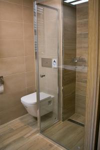 a bathroom with a toilet and a glass shower at Hotel Korona in Kłodzko