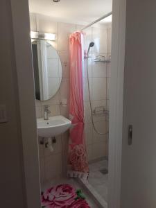 a bathroom with a sink and a shower with a mirror at Heavenly joy in Patra