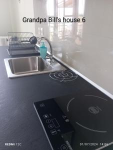 a kitchen counter with a sink and a remote control at Grandpa BILL's house 6 in Pyrgadikia