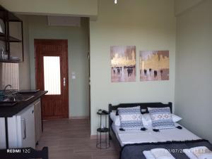 a bedroom with a bed and a kitchen with a window at Grandpa BILL's house 6 in Pyrgadikia
