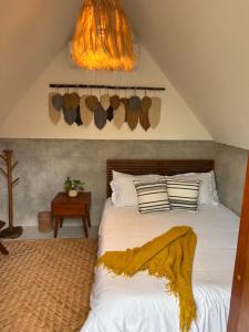 a bedroom with a bed with a yellow blanket on it at Aldea Pukna Tulum in Akumal +52 photos