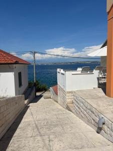 a walkway between two buildings with the ocean in the background at Lana&Ema in Kali