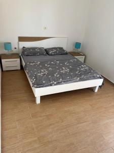 a bed in a room with two night stands and two lamps at Lana&Ema in Kali