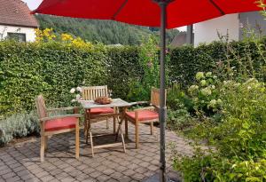 a table and chairs under an umbrella on a patio at Ferienwohnungen Zur Tenne in Beckingen