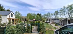 a yard with a fence and a house at Domek ASIA in Wronka