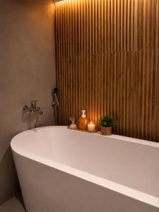 a large white tub in a bathroom with a shower at Pousada Telhado de Ouro in Campos do Jordão