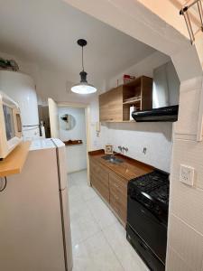 a kitchen with a black refrigerator and a stove at Alsina Mdq in Mar del Plata +12 photos