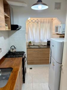 a kitchen with a white refrigerator and a sink at Alsina Mdq in Mar del Plata