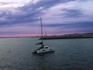 a boat in the water under a cloudy sky at Palazzo Tirso MGallery Cagliari in Cagliari