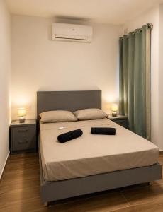 a bedroom with a bed with two pillows on it at New Apartment - 3 min to Airport - 10 min to Valletta in Gudja