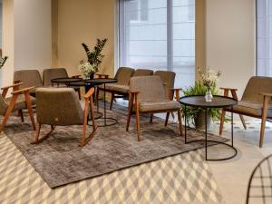 a waiting room with chairs and tables on a rug at ibis Lviv Center in Lviv