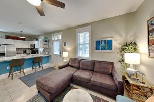 a living room with a brown couch and a kitchen at Bungalows at Seagrove #142 in Seagrove Beach
