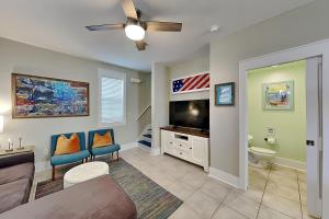 a living room with a couch and a flat screen tv at Bungalows at Seagrove #142 in Seagrove Beach +25 photos