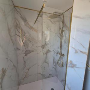 a bathroom with a shower with a marble wall at Appartement neuf full équipe in Palavas-les-Flots