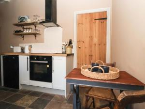 a kitchen with a table with a basket on it at The Cooks Cottage in Malton
