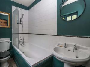a bathroom with a tub and a sink and a mirror at The Cooks Cottage in Malton +14 photos