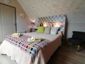 a bedroom with a large bed and a chair at Les Gites de Kerdurod in Guidel