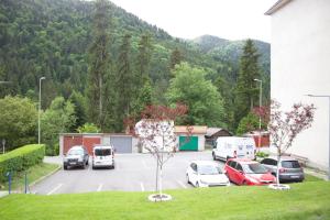 a parking lot with cars parked in front of a mountain at Natasa apartment in Băile Tuşnad