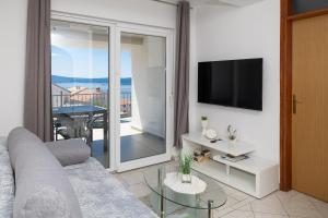a living room with a couch and a television at Apartments Baretić in Crikvenica