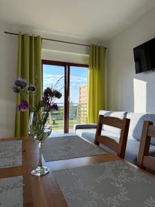 a living room with a table with a vase of flowers at Pod Kasztanami in Międzylesie
