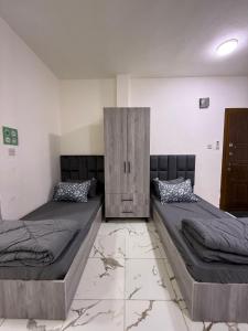 a bedroom with two beds and a cabinet at Makank Jo in Aqaba +7 photos