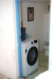 a washing machine in a room with a toilet at Rocky Beach House in Kythira