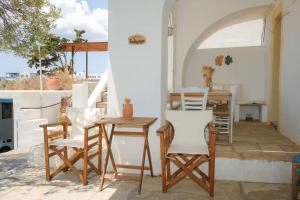 a patio with chairs and a table and a table at Rocky Beach House in Kythira