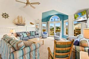 a living room with a couch and a table at 6170 - Poolside Paradise in Nags Head