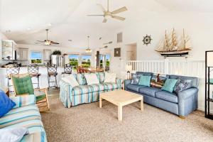 a living room with two couches and a table at 6170 - Poolside Paradise in Nags Head