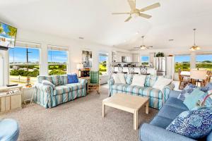 a living room with couches and a table at 6170 - Poolside Paradise in Nags Head +58 photos