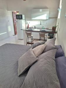 a bedroom with a bed with pillows and a kitchen at Rainha do gelo in Barra Grande +13 photos