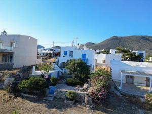 a group of white buildings with trees and flowers at Rocky Beach House in Kythira