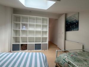 a bedroom with white shelves and a bed at 225 rue de la source in Bretignolles-sur-Mer