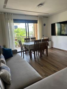 a living room with a couch and a table and chairs at Joli appartement à Tamaris in Dar Bouazza