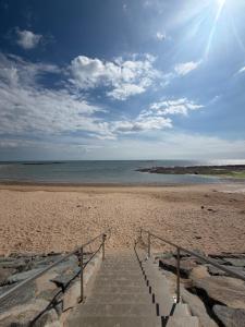a stairway leading down to a sandy beach at 225 rue de la source in Bretignolles-sur-Mer