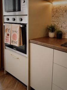 a kitchen with a stove and a microwave at New Apartment - 3 min to Airport - 10 min to Valletta in Gudja