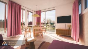 a living room with pink curtains and a table with chairs at Waddenlodge Premium in Harlingen