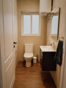 a bathroom with a toilet and a sink and a window at New Apartment - 3 min to Airport - 10 min to Valletta in Gudja +9 photos